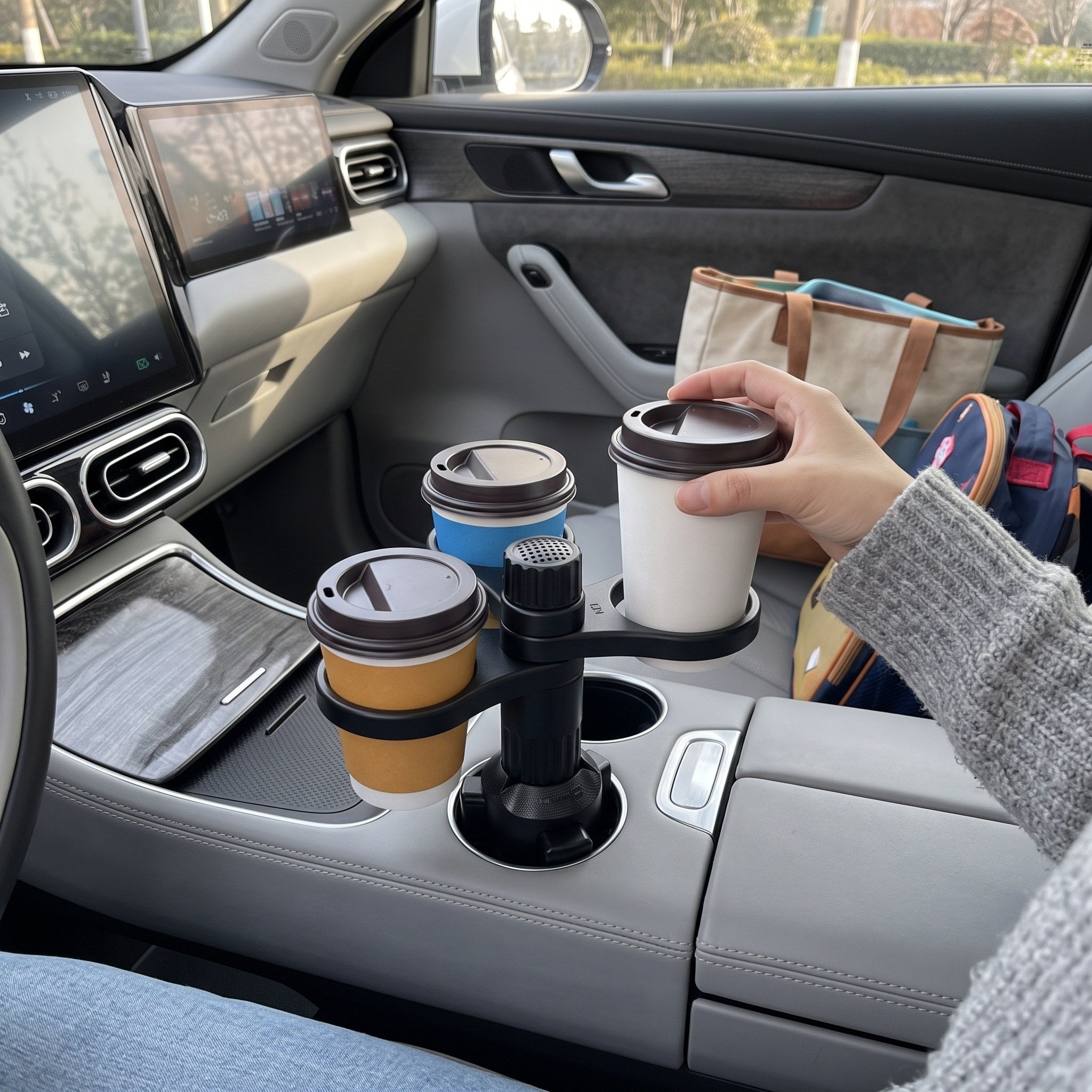 Hand placing a cup into a parked-car holder