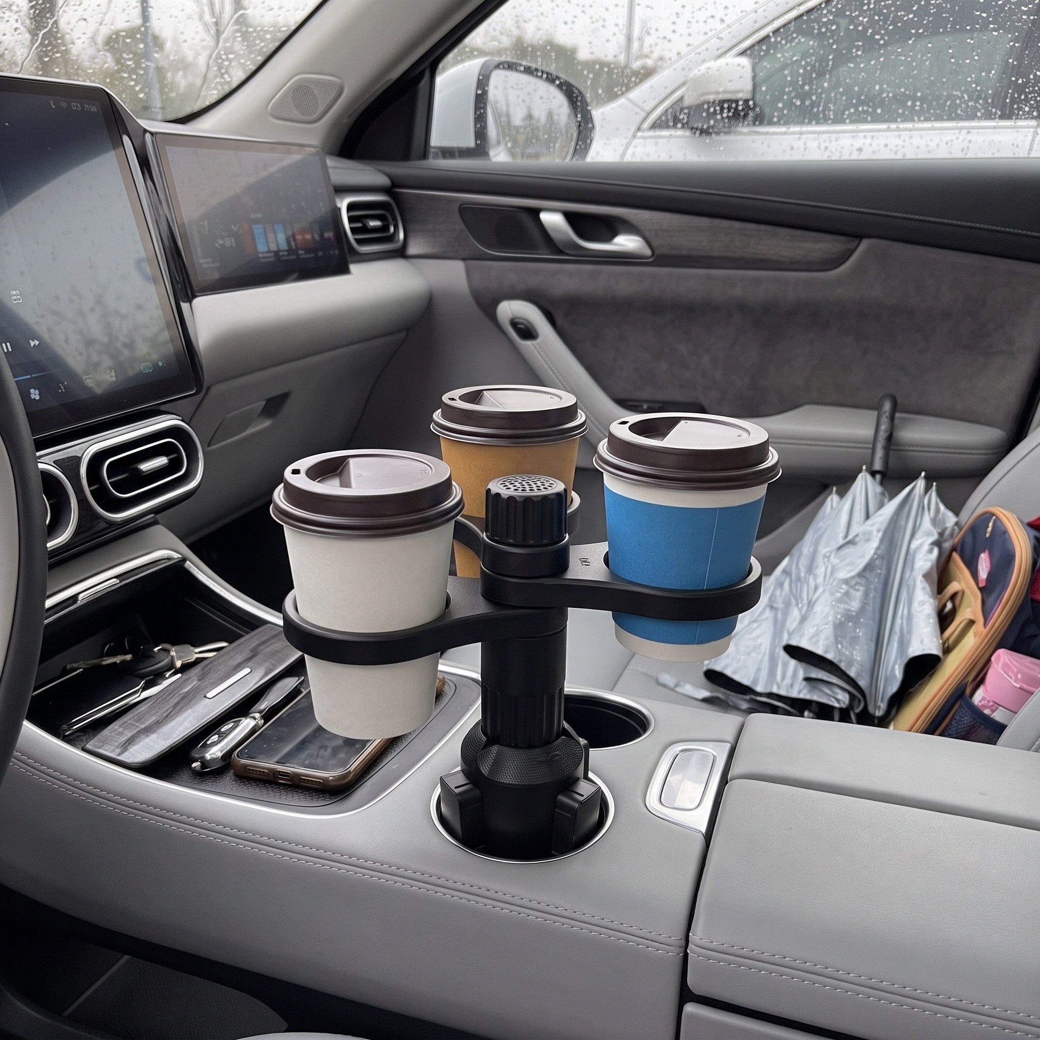 Three closed takeaway cups in a parked car on a rainy day